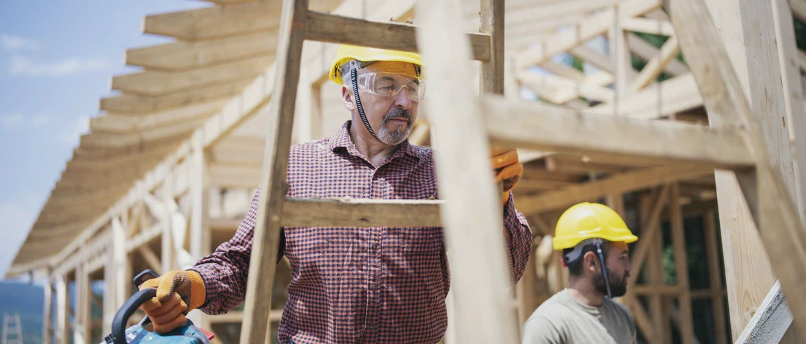 Pracownik budowy na&nbsp;drabinie